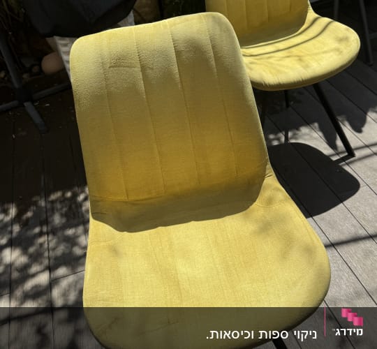 שני כיסאות צהובים על רצפת עץ בחוץ